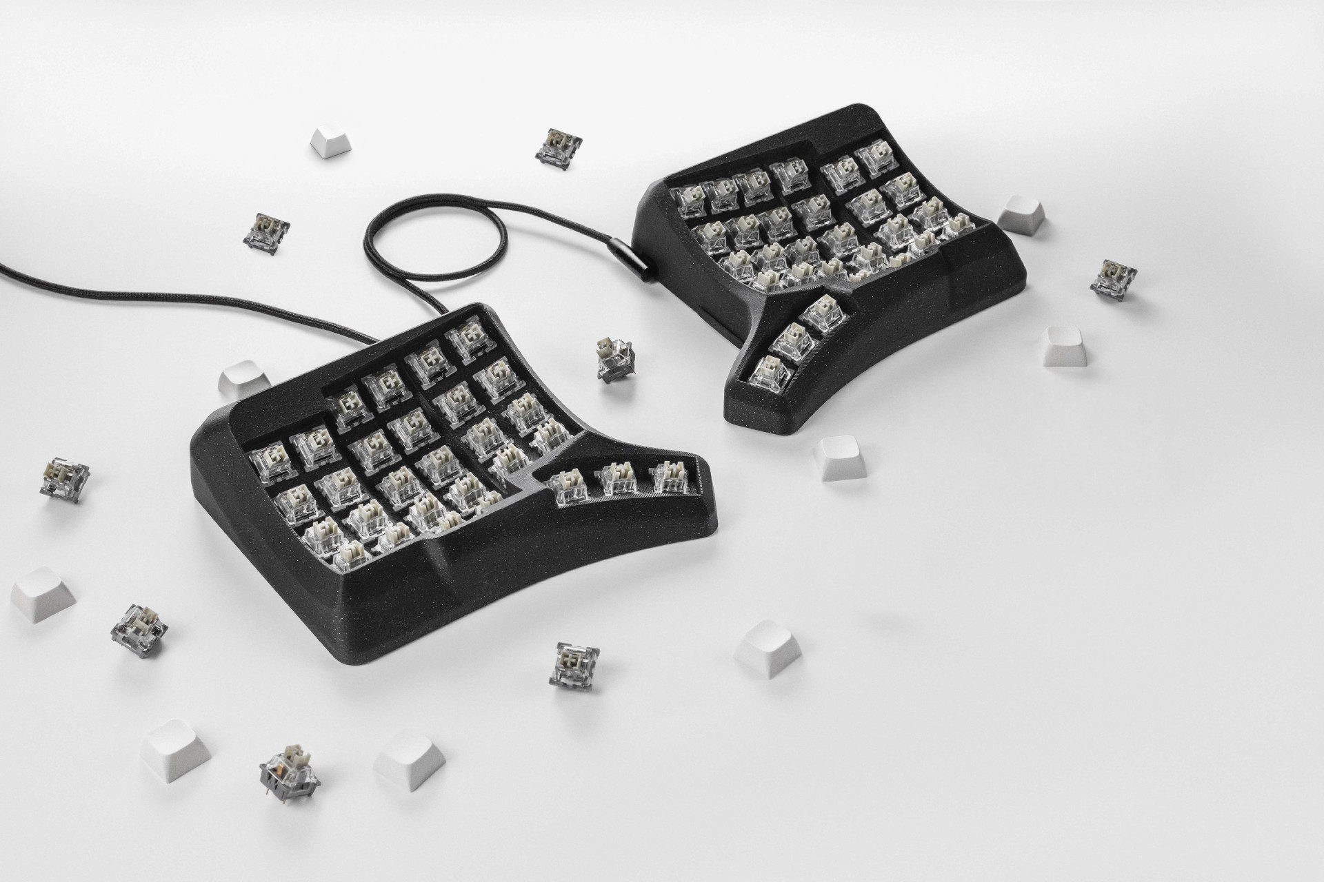 Phenom split keyboard with exposed mechanical switches and loose white keycaps